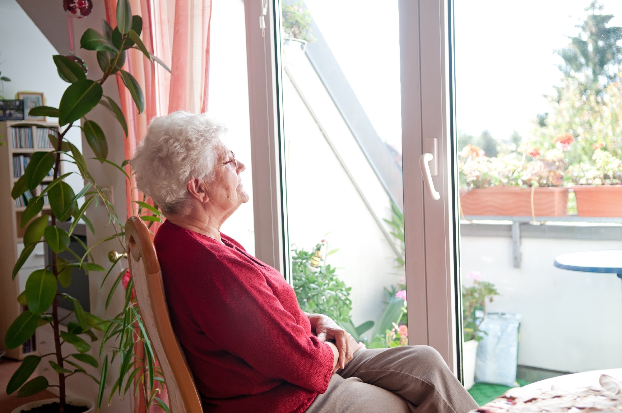 older woman sitting at home looking out